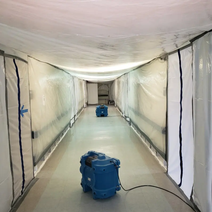 Dehumidifier and air mover running on a wood floor in a Great Neck room after water removal