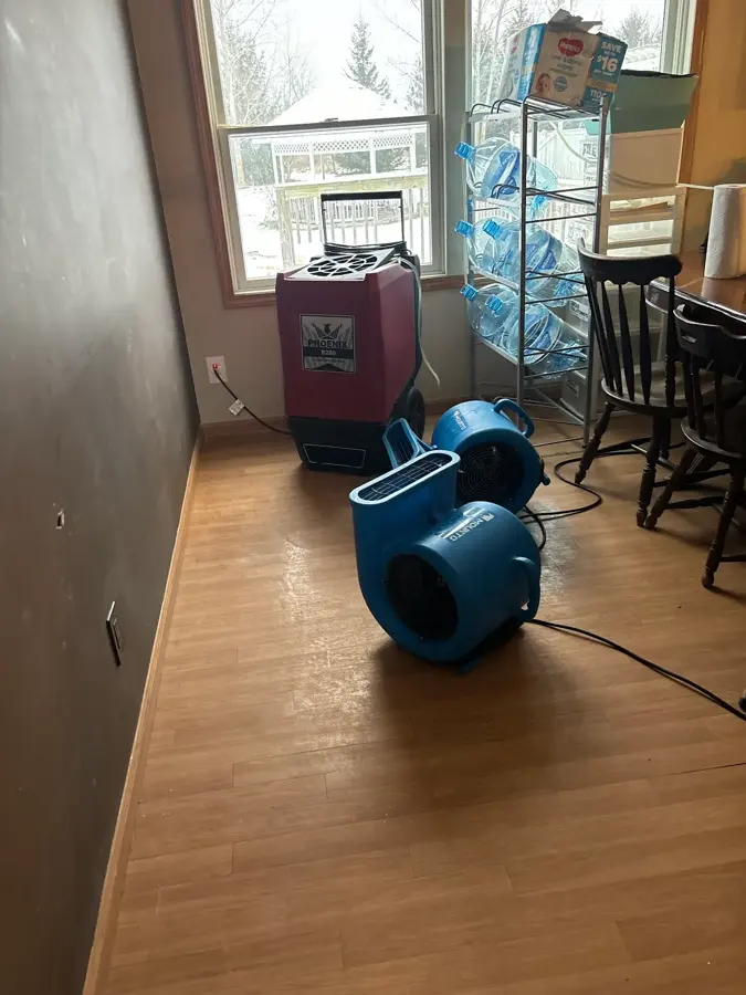Dehumidifier and air mover drying a wet floor in a New Hyde Park house